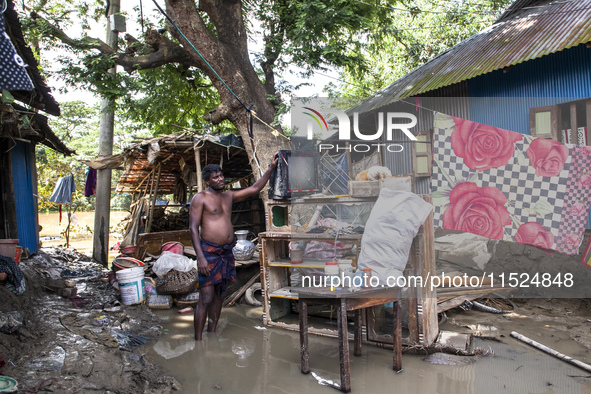 A man tries to collect damaged and scattered items in flood waters in the Gopal area of Chagalnaia Upazila in Feni district of Chittagong di...