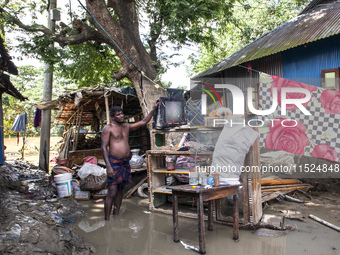 A man tries to collect damaged and scattered items in flood waters in the Gopal area of Chagalnaia Upazila in Feni district of Chittagong di...