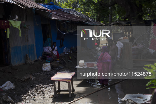 A flood-affected family places rice on a table to dry in the low sun in the Gopal area of Chagalnaya upazila, Feni district, Chittagong divi...