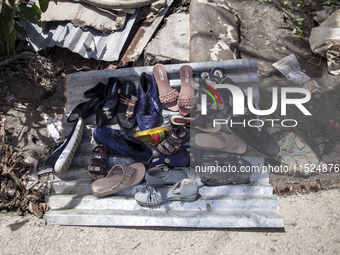 A flood-affected family puts their shoes on a tin to dry in the little sun in the Gopal area of Chagalnaiya upazila, Feni district, Chittago...