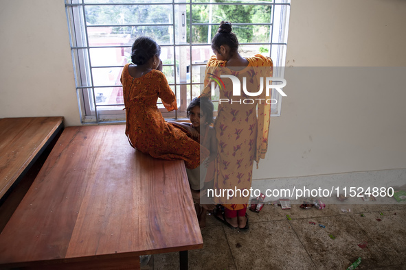 A few little girls stand by the window on the balcony of a shelter in Chagalnaya Upazila, Feni District, Chittagong Division, Bangladesh, on...