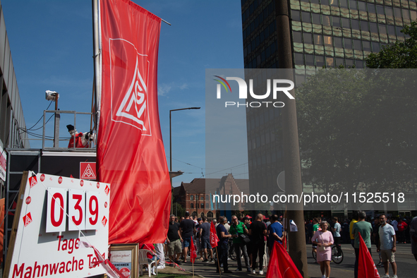 A thousand steel workers stand in front of the gate of the Thyssenkrupp industrial area in Duisburg, Germany, on August 29, 2024, as the IG...