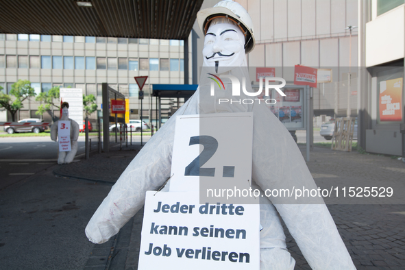 A dummy steelworker holds a sign reading ''one of three people will lose job'' in front of the gate of the Thyssenkrupp industrial area in D...