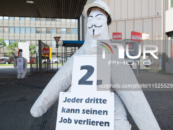 A dummy steelworker holds a sign reading ''one of three people will lose job'' in front of the gate of the Thyssenkrupp industrial area in D...