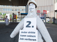 A dummy steelworker holds a sign reading ''one of three people will lose job'' in front of the gate of the Thyssenkrupp industrial area in D...