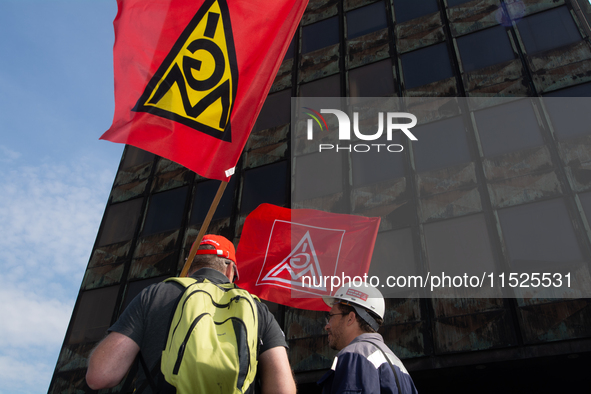 A thousand steel workers stand in front of the gate of the Thyssenkrupp industrial area in Duisburg, Germany, on August 29, 2024, as the IG...