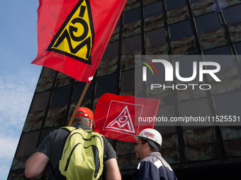 A thousand steel workers stand in front of the gate of the Thyssenkrupp industrial area in Duisburg, Germany, on August 29, 2024, as the IG...