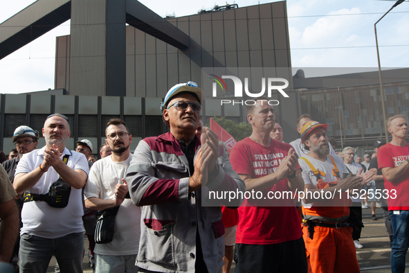 A thousand steel workers stand in front of the gate of the Thyssenkrupp industrial area in Duisburg, Germany, on August 29, 2024, as the IG...