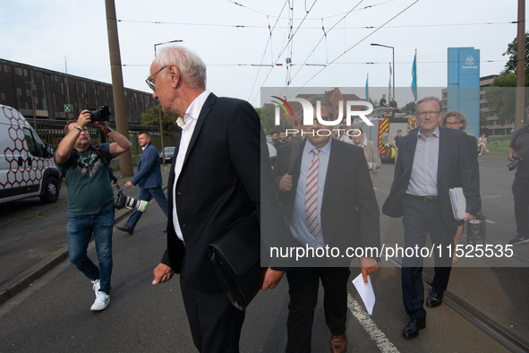 Sigmar Gabriel, the head of the supervisory board, comes toward the press conference site as a thousand steel workers stand in front of the...