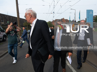 Sigmar Gabriel, the head of the supervisory board, comes toward the press conference site as a thousand steel workers stand in front of the...