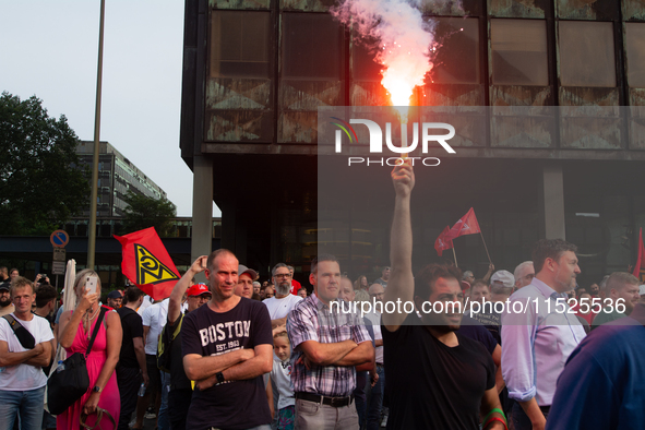 A thousand steel workers stand in front of the gate of the Thyssenkrupp industrial area in Duisburg, Germany, on August 29, 2024, as the IG...