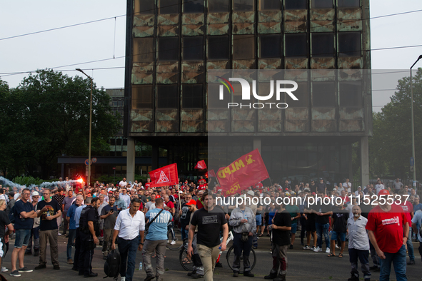 A thousand steel workers stand in front of the gate of the Thyssenkrupp industrial area in Duisburg, Germany, on August 29, 2024, as the IG...