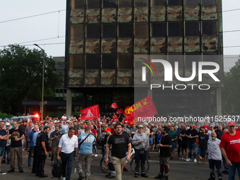 A thousand steel workers stand in front of the gate of the Thyssenkrupp industrial area in Duisburg, Germany, on August 29, 2024, as the IG...