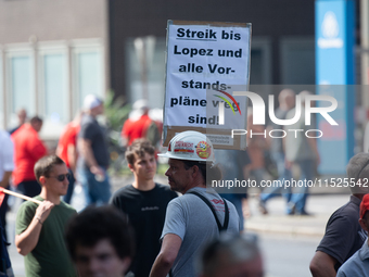 A thousand steel workers stand in front of the gate of the Thyssenkrupp industrial area in Duisburg, Germany, on August 29, 2024, as the IG...