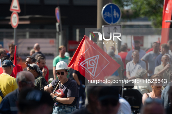 A thousand steel workers stand in front of the gate of the Thyssenkrupp industrial area in Duisburg, Germany, on August 29, 2024, as the IG...