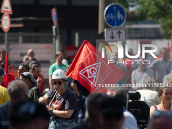 A thousand steel workers stand in front of the gate of the Thyssenkrupp industrial area in Duisburg, Germany, on August 29, 2024, as the IG...