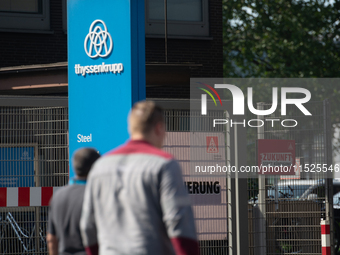 A thousand steel workers stand in front of the gate of the Thyssenkrupp industrial area in Duisburg, Germany, on August 29, 2024, as the IG...