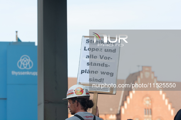 A thousand steel workers stand in front of the gate of the Thyssenkrupp industrial area in Duisburg, Germany, on August 29, 2024, as the IG...