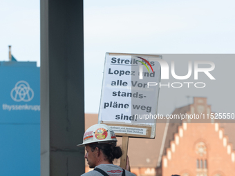 A thousand steel workers stand in front of the gate of the Thyssenkrupp industrial area in Duisburg, Germany, on August 29, 2024, as the IG...