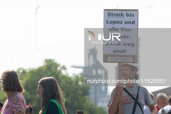 A thousand steel workers stand in front of the gate of the Thyssenkrupp industrial area in Duisburg, Germany, on August 29, 2024, as the IG...