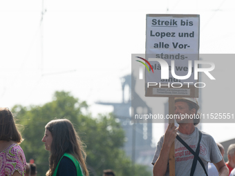 A thousand steel workers stand in front of the gate of the Thyssenkrupp industrial area in Duisburg, Germany, on August 29, 2024, as the IG...