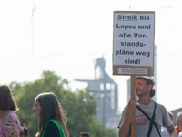 A thousand steel workers stand in front of the gate of the Thyssenkrupp industrial area in Duisburg, Germany, on August 29, 2024, as the IG...