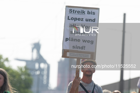 A thousand steel workers stand in front of the gate of the Thyssenkrupp industrial area in Duisburg, Germany, on August 29, 2024, as the IG...