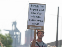 A thousand steel workers stand in front of the gate of the Thyssenkrupp industrial area in Duisburg, Germany, on August 29, 2024, as the IG...