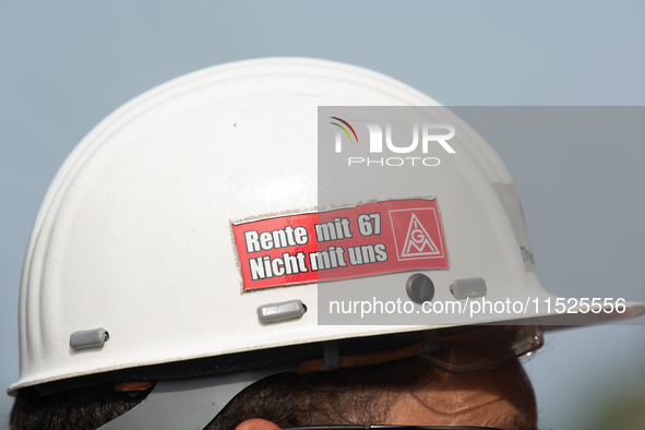 A thousand steel workers stand in front of the gate of the Thyssenkrupp industrial area in Duisburg, Germany, on August 29, 2024, as the IG...