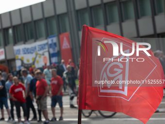 A thousand steel workers stand in front of the gate of the Thyssenkrupp industrial area in Duisburg, Germany, on August 29, 2024, as the IG...