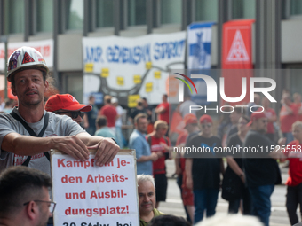 A thousand steel workers stand in front of the gate of the Thyssenkrupp industrial area in Duisburg, Germany, on August 29, 2024, as the IG...