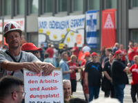 A thousand steel workers stand in front of the gate of the Thyssenkrupp industrial area in Duisburg, Germany, on August 29, 2024, as the IG...