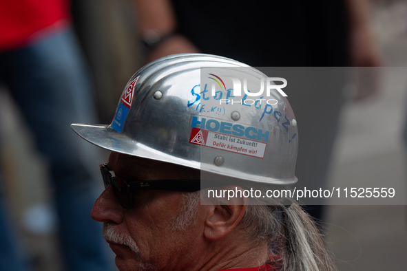 A thousand steel workers stand in front of the gate of the Thyssenkrupp industrial area in Duisburg, Germany, on August 29, 2024, as the IG...