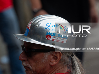 A thousand steel workers stand in front of the gate of the Thyssenkrupp industrial area in Duisburg, Germany, on August 29, 2024, as the IG...