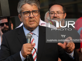 Sigmar Gabriel, the head of the supervisory board, speaks to the steelworkers after the press conference as a thousand steelworkers stand in...