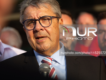 Sigmar Gabriel, the head of the supervisory board, speaks to the steelworkers after the press conference as a thousand steelworkers stand in...