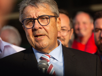 Sigmar Gabriel, the head of the supervisory board, speaks to the steelworkers after the press conference as a thousand steelworkers stand in...