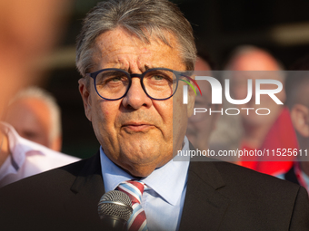 Sigmar Gabriel, the head of the supervisory board, speaks to the steelworkers after the press conference as a thousand steelworkers stand in...