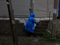 A man clears a bucket filled with rainwater in Sopore, Jammu and Kashmir, India, on August 30, 2024 (