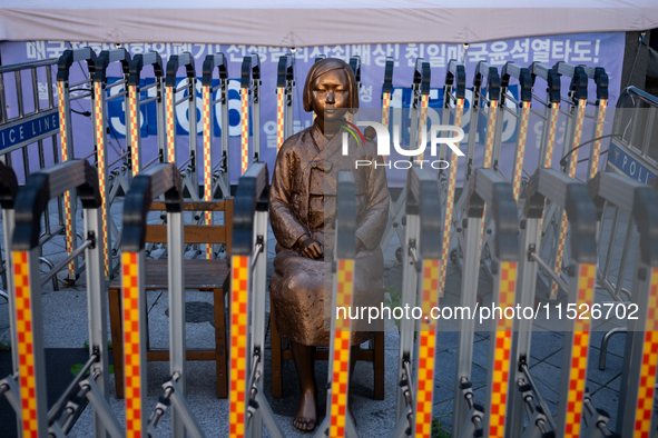 The Comfort Woman statue in front of the Yonhap News Agency building in Susong-dong, Seoul, is surrounded by barricades to prevent attacks f...