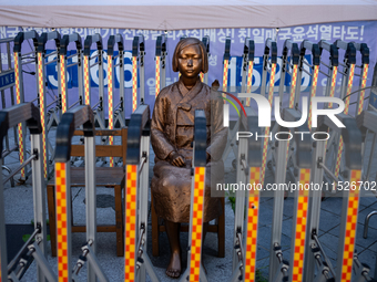 The Comfort Woman statue in front of the Yonhap News Agency building in Susong-dong, Seoul, is surrounded by barricades to prevent attacks f...