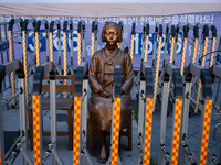 The Comfort Woman statue in front of the Yonhap News Agency building in Susong-dong, Seoul, is surrounded by barricades to prevent attacks f...