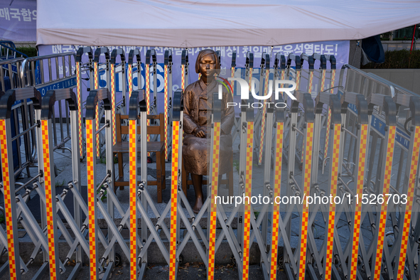 The Comfort Woman statue in front of the Yonhap News Agency building in Susong-dong, Seoul, is surrounded by barricades to prevent attacks f...