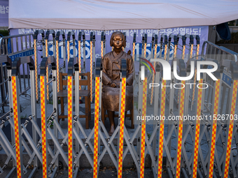 The Comfort Woman statue in front of the Yonhap News Agency building in Susong-dong, Seoul, is surrounded by barricades to prevent attacks f...