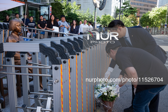 Members of the Democratic Party Youth Committee lay flowers in front of the Comfort Woman statue after holding the inauguration ceremony for...