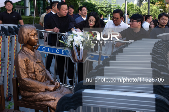 Members of the Democratic Party Youth Committee lay flowers in front of the Comfort Woman statue after holding the inauguration ceremony for...