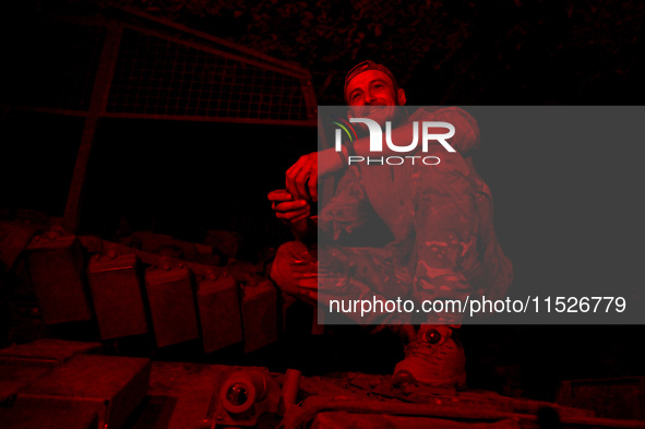 A tanker of the 118th Separate Mechanized Brigade poses for a photo on a T-72 tank during the night firing exercise in the Zaporizhzhia sect...