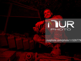 A tanker of the 118th Separate Mechanized Brigade poses for a photo on a T-72 tank during the night firing exercise in the Zaporizhzhia sect...