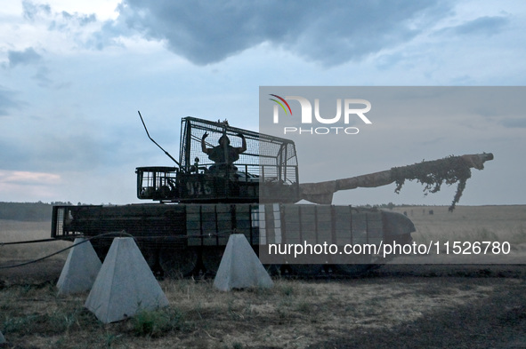 A tanker of the 118th Separate Mechanized Brigade poses for a photo on a T-72 tank before the start of the night firing exercise in the Zapo...