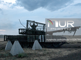 A tanker of the 118th Separate Mechanized Brigade poses for a photo on a T-72 tank before the start of the night firing exercise in the Zapo...